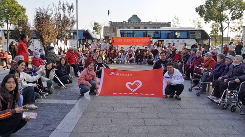 87a8a68eaa504f70a0d19a997a8b85aa.jpg 志愿团成员与老人们合影.jpg